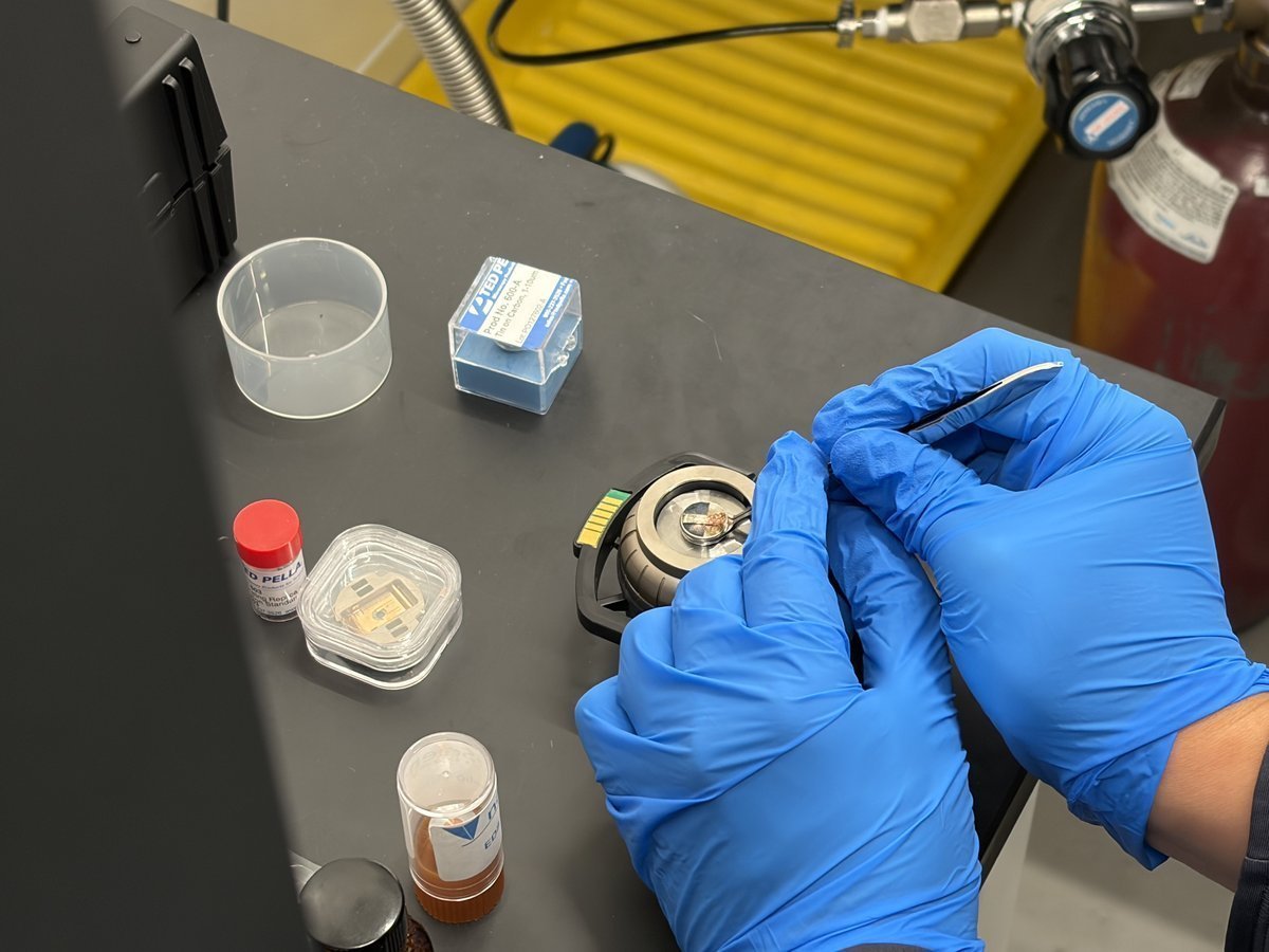 Empty stub puck held in hand with new copper sample ready to be placed