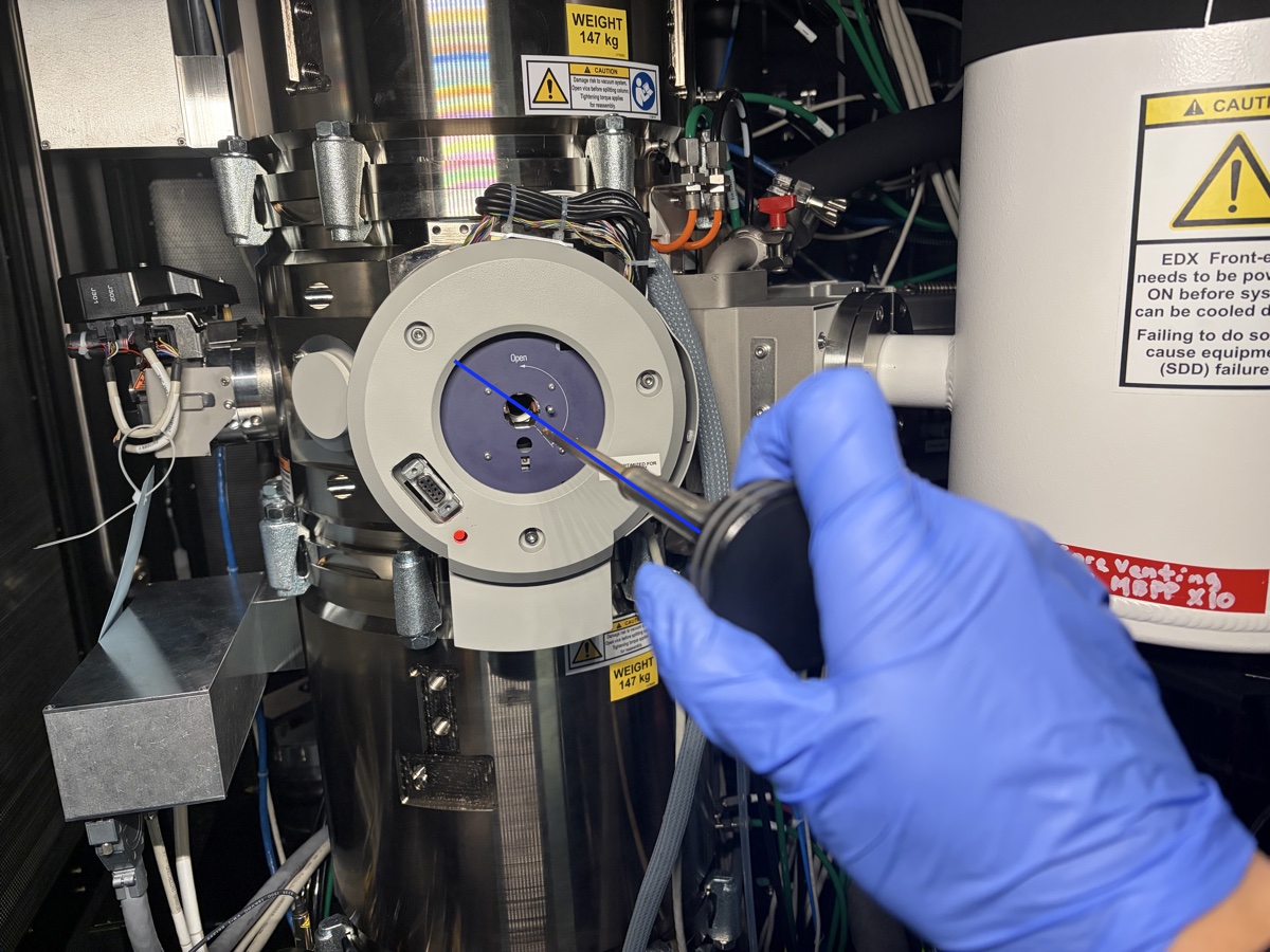 Holder aligned with blue line on goniometer, gloved hand